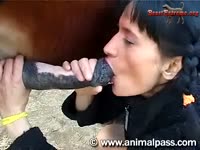 Brunette sucking and licking a horse dick